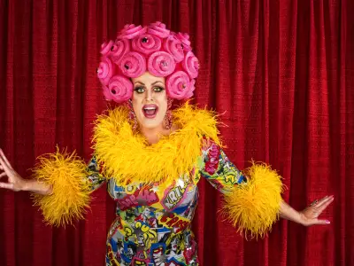 Big drag queen performing a song in theater
