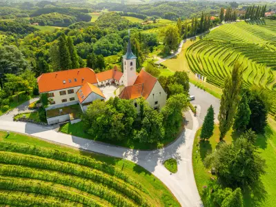 Picturesque scene with the charming Church of the Sorrowful Mother of God nestled amidst magnificent vineyards in the Jeruzalem winery region of Slovenia. Aerial drone view
