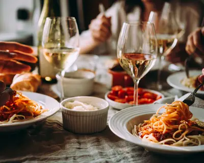 Friends having a pasta dinner at home of at a restaurant.