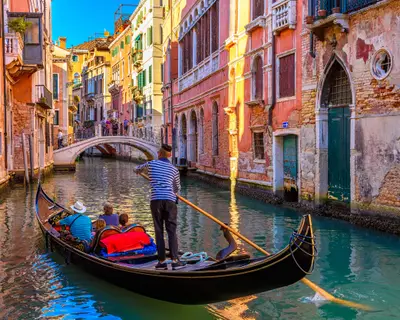 Narrow canal with gondola and bridge in Venice, Italy. Architecture and landmark of Venice. Cozy cityscape of Venice.