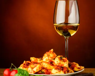 traditional italian tortellini pasta with tomato sauce, basil and white wine