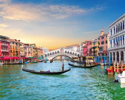 Venice Grand Canal, view of the Rialto Bridge and gondoliers, Italy.