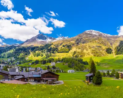 Wooden cottage houses on green fields, Davos, Graubuenden, Switzerland
